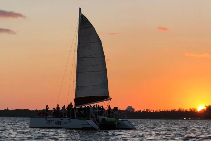 a sunset behind a boat on a body of water