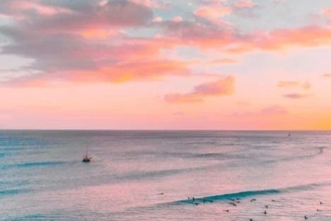 a sunset over a beach next to the ocean